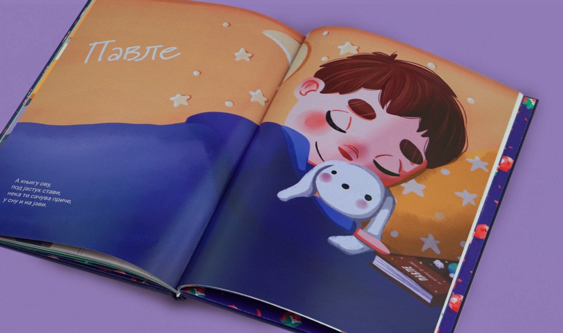 Otvorena knjiga na kojoj se vidi ilustracija dečaka koji spava